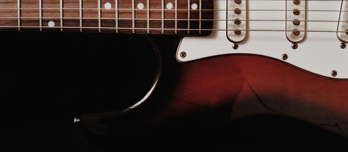 Detailed shot of an electric guitar with a dark background emphasizing the instrument's features.